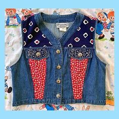 a child's denim vest with patches on it