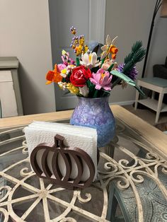 a vase filled with flowers sitting on top of a glass table next to a card holder