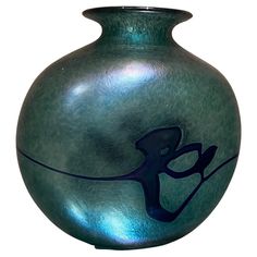 a green vase with a blue design on it