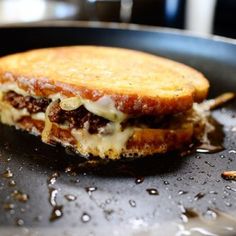 a grilled cheese sandwich sitting on top of a frying pan