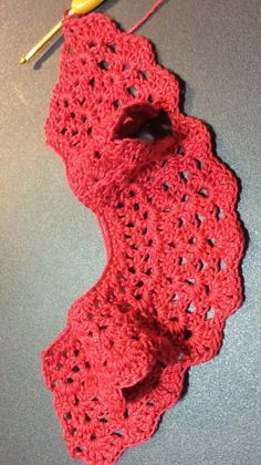 there is a crocheted red scarf on the table