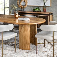 a dining room table with white chairs and a mirror on the wall above it,