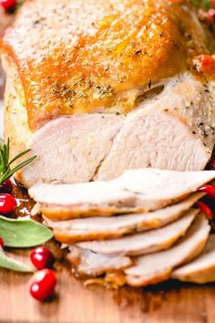 sliced turkey with cranberries and rosemary on the side