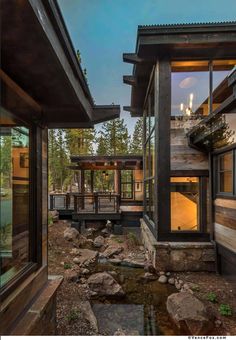 an exterior view of a house in the woods at night with water running through it