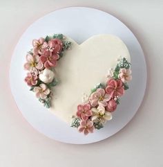 a heart shaped cake decorated with flowers on a plate