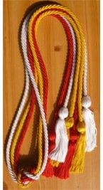 three tassels on a wooden surface, one is red and the other is yellow