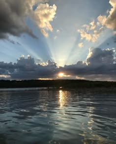 the sun is shining through clouds over water