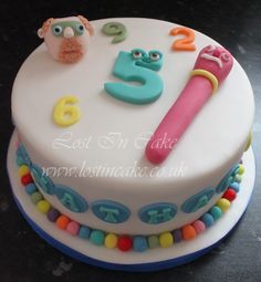 a birthday cake with the number five on it and an owl holding a pencil in its mouth