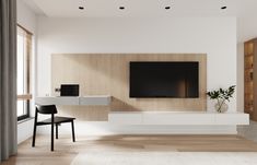 a modern living room with white walls and wood flooring, large screen tv on the wall