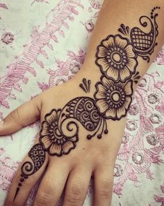 a woman's hand with henna tattoos on it, and an intricate design