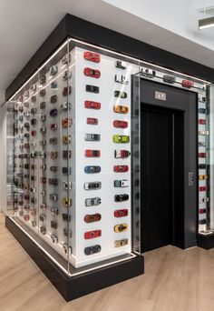 a display case filled with lots of different types of cell phones on glass shelves next to wooden flooring