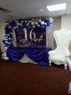 a chair sitting in front of a table with balloons on it and a sign that says sweet sixteen