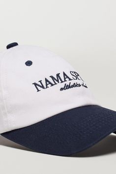 Description Crafted from cotton canvas, this cap features a timeless two-tone finish and an embroidered logo, making it a must-have for your off duty look. 100% cotton twill fabric Adjustable back strap Matte nickel buckle 6 panel Unisex fit 'NAMA SPORT' logo embroidery Complete the look: Body Butter™ Crop Jacket Fabric & Fit 100% Cotton Adjustable fit Model is 5'9", 36" Bust, 28" Waist, 42" Hips, and wears a size small top and medium bottom. Shipping & Returns Visit our Shipping and Returns pag Cotton Hat With Logo And Curved Visor, Cotton Curved Visor Hat With Logo, Cotton Hat With Curved Visor And Logo, Cotton Baseball Cap With Curved Brim And Logo, Cotton Baseball Cap With Logo, Cotton Six-panel Hat With Logo, Adjustable Cotton Baseball Cap With Logo Print, Adjustable Cotton Baseball Cap With Logo, Adjustable Six-panel Hat With Logo Print