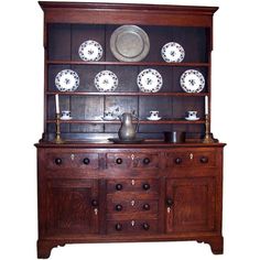 an old wooden china cabinet with plates on it