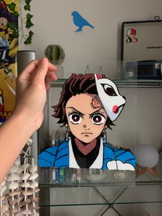 a person holding up a paper cut out of an anime character