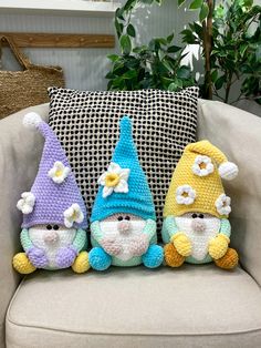 three crocheted gnomes sitting on top of a couch