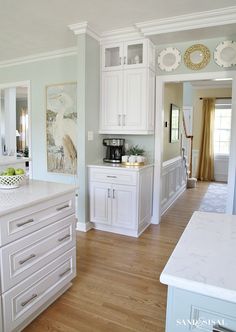 a large kitchen with white cabinets and wood flooring, along with a breakfast nook