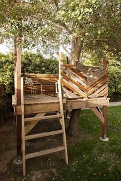 a tree stand made out of pallets and wooden planks with a ladder up to it