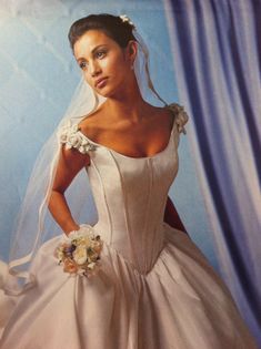 a woman in a wedding dress posing for the camera