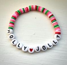 Heishi beaded bracelet that is ~7 inches long (average women's size bracelet). Heishi bead colors: variations of pink and green, red. Letter beads are black and white. Bracelet Heishi, Lei Lei, Clay Bracelets, Bubble Necklace, Disney World Outfits, Friendship Bracelets With Beads, Bubble Necklaces