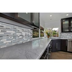 a kitchen with marble counter tops and stainless steel appliances