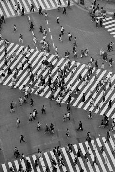 an aerial view of people walking across a crosswalk in the city with zebra crossing