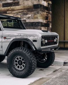 an off - road vehicle is parked on the side of the street in front of a building