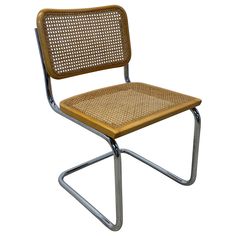 a chair that is made out of wood and metal with a woven seat pad on the back