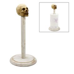 a white and gold skull head on top of a toilet paper holder