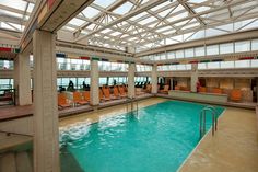 an indoor swimming pool with orange chairs