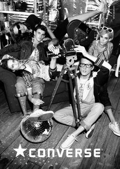 a group of young men sitting on top of a wooden floor next to each other