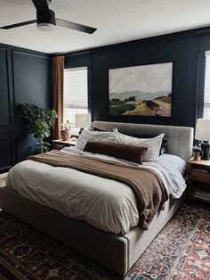 a large bed sitting in the middle of a bedroom next to a painting on the wall