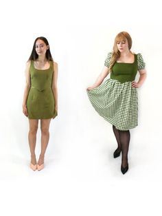 two women in dresses standing next to each other on a white background and one is wearing black tights