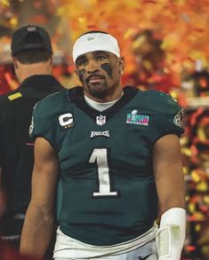 a football player with his face painted in the colors of green and white is standing on the field