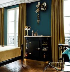 a bedroom with blue walls and gold curtains