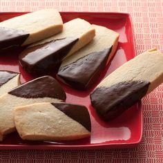 several pieces of chocolate and vanilla shortbread on a red plate with pink tablecloth