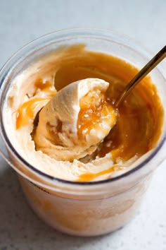 an ice cream dessert with caramel sauce in a plastic cup on a table top