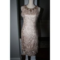 Beautiful Gold Lace Sheath Dress By Boston Proper. This Knee Length Dress Is All Lace And Is Fully Lined. The Dress Lining Has Adjustable Lingerie Style Straps For A Perfect Fit. Back Zipper With Hook And Eye At The Back Neck. Rhinestone Trim Goes All The Way Around The Neckline. Measurements As Follows: Length: 35.5" At Center Back Bust: 34" Waist: 29" Lace Is 100% Polyester. Lining Is Poly/Spandex. Dry Clean Only. New With Tag Please Email Me With Any Questions. Items Ship Within 2 Days Of Pay Elegant Stretch Dress With Rhinestones, Elegant Spring Dresses With Rhinestones, Evening Lace Dresses With Rhinestones, Elegant Lace Dress With Rhinestones, Knee-length Lace Trim Midi Dress For Cocktail, Evening V-neck Mini Dress With Lace Trim, Gold Embroidered V-neck Dress, Evening V-neck Flapper Dress, Embellished Fitted V-neck Flapper Dress