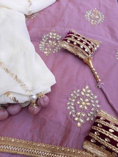 Item Overview ATHARVA Hand Embroidered Salwar Kameez w/Embroidered Jaal Center Panel/ Side Gota Work on Lilac/Chiffon Chinnon Dupatta/ Customized Stitching/Wedding/CH1237 Fabric: * Shirt Chanderi Silk- 2.5 Mts - with Hand Embroidered Neck - Lilac * Dupatta: 2.5 Mts - Chiffon Chinnon Dupatta / Gota Patti work Jaal * Bottom Santoon Silk 2.5 Mts. Excusive Hand Embroidered Party Wear Punjabi Suit. Customization: * Fabrics: Designs Can be made in different Fabrics. * Stitching Available Care: * Dry C Traditional Purple Sharara With Gota Work, Purple Salwar Kameez With Gota Work For Wedding, Anarkali Churidar With Dori Work For Wedding, Purple Lehenga With Gota Work For Eid, Eid Wedding Sharara With Dori Work, Embroidered Kundan Sets For Wedding, Purple Dola Silk Lehenga With Gota Work, Embroidered Kundan Traditional Wear For Wedding, Embroidered Dola Silk Sets For Wedding