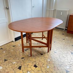 a wooden table sitting on top of a tiled floor next to a radiator