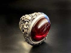 RING PROFILE: 🔱 Indulge in the allure of the 'Devil's Blood Ring,' a captivating piece that embodies the mystique of dark elegance. Crafted with precision and imbued with a touch of the infernal, this ring is a mesmerizing fusion of sophistication and edge. The deep, crimson hues evoke a sense of forbidden passion, while the intricate design channels the essence of the occult. Elevate your style with this unique accessory that beckons the daring and those drawn to the darker realms. The Devil's Luxury Silver Ruby Cabochon Ring, Formal Cabochon Ruby Ring, Mystical Gemstone Rings For Formal Occasions, Unique Cabochon Ruby Ring For Formal Occasions, Unique Formal Rings With Polished Finish, Gothic Hallmarked Rings For Collectors, Formal Red Engraved Ring With Polished Finish, Collectible Gothic Rings With Polished Finish, Mystical Gemstone Jewelry For Formal Occasions