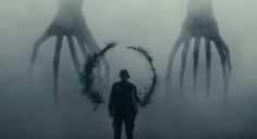 a man standing in front of two giant squid like creatures with their heads turned to the side