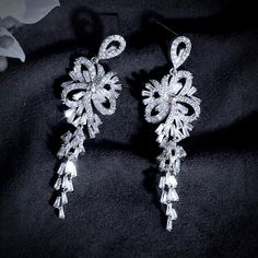 A delightfully unique pair of bridal earrings with an incredible sparkle! Adorned with flawlessly faceted cubic zirconia that capture the light in a dazzling array of sparkles, the earrings are rhodium plated for a bright finish which enhances the intricate detailing and conveys a modern take on old elegance. Length: 60mm (approx. 2.3"). Width: 18mm (approx. 0.7"). Weight: 11g. Available in Silver and Rose Gold finishes. To make your choice select your preferred finish from the dropdown menu to Bridal Earrings Silver, Cubic Zirconia Bridal Earrings, Silver Bridal Earrings, Silver Wedding Jewelry, Silver Rose Gold, Silver Roses, Earrings Silver, Bridal Earrings, Exquisite Design