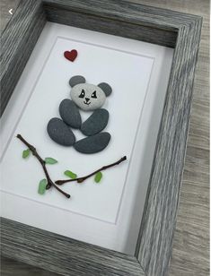 a panda bear sitting on top of a tree branch with a heart in it's mouth