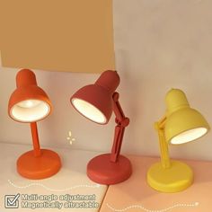 three different colored desk lamps sitting on top of a white table next to a lamp shade