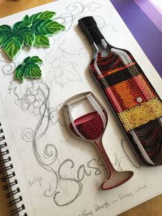 a wine bottle and glass sitting on top of a table next to some paper decorations