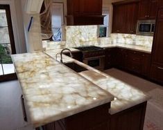 a kitchen with marble counter tops and wooden cabinets