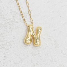 Bubbling with personality, this initial pendant infuses your everyday jewelry lineup with a bold and personalized accessory that creates your individuality! When we found these bubble letter charms we knew we needed to design our own version. Handmade in house at E&O with a tiny gold paperclip chain and lobster clasp. Of course we knew we had to offer this gem in 2 lengths for personal preference!! Features: Gold plated paperclip chain in 16' and 19" lengths 24K gold plated bubble letter charm L Bubble Letter Necklace, Gold Bubbles, Bubble Letter, Bubble Letters, Letter Charm, Stone Collection, Letter Charms, Initial Pendant, Charm Set