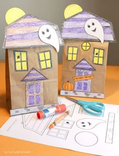 two paper houses with halloween decorations on them