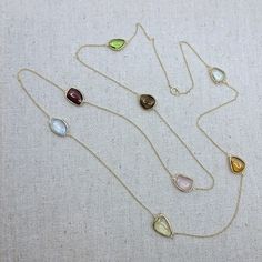 Semi-precious stone with 18k Solid Gold Necklace Stone: Semi-Precious Stone (Citrine, Blue Topaz, Rose Quartz, Lemon Quartz, Garnet, Green Amethyst, Peridot, Smokey Quartz)           -Shape: Free Form           -Cut: Double-Sided Cabochon           -Color: Orange, Blue, Pink, Yellow, Red, Light Green, Brown, Green           -Weight: ~26ct           -Quantity:  8 pieces           -Quality: Please refer to the picture, only 1 piece is available Necklace Length: 81cm (32in) The stones were bezel-se Yellow Multi-stone Round Gemstones, Briolette Natural Stone Necklace For Wedding, Formal Multi-stone Drop Jewelry, Yellow Gemstones With Accents Fine Jewelry, Briolette Necklace With Natural Stones For Anniversary, Fine Jewelry Teardrop Gemstones With Accents, Yellow Gold Briolette Gemstones For Formal Occasions, Yellow Gold Citrine Gemstones With Multi-stone Detail, Anniversary Briolette Necklace With Natural Stones